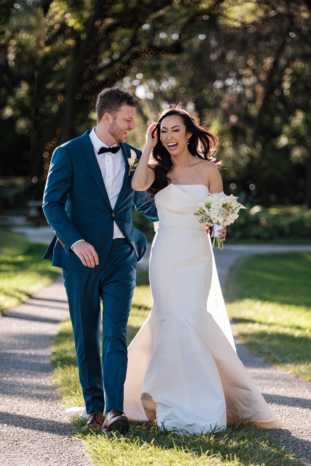 A couple walking and laughing together outdoors after their Miami wedding