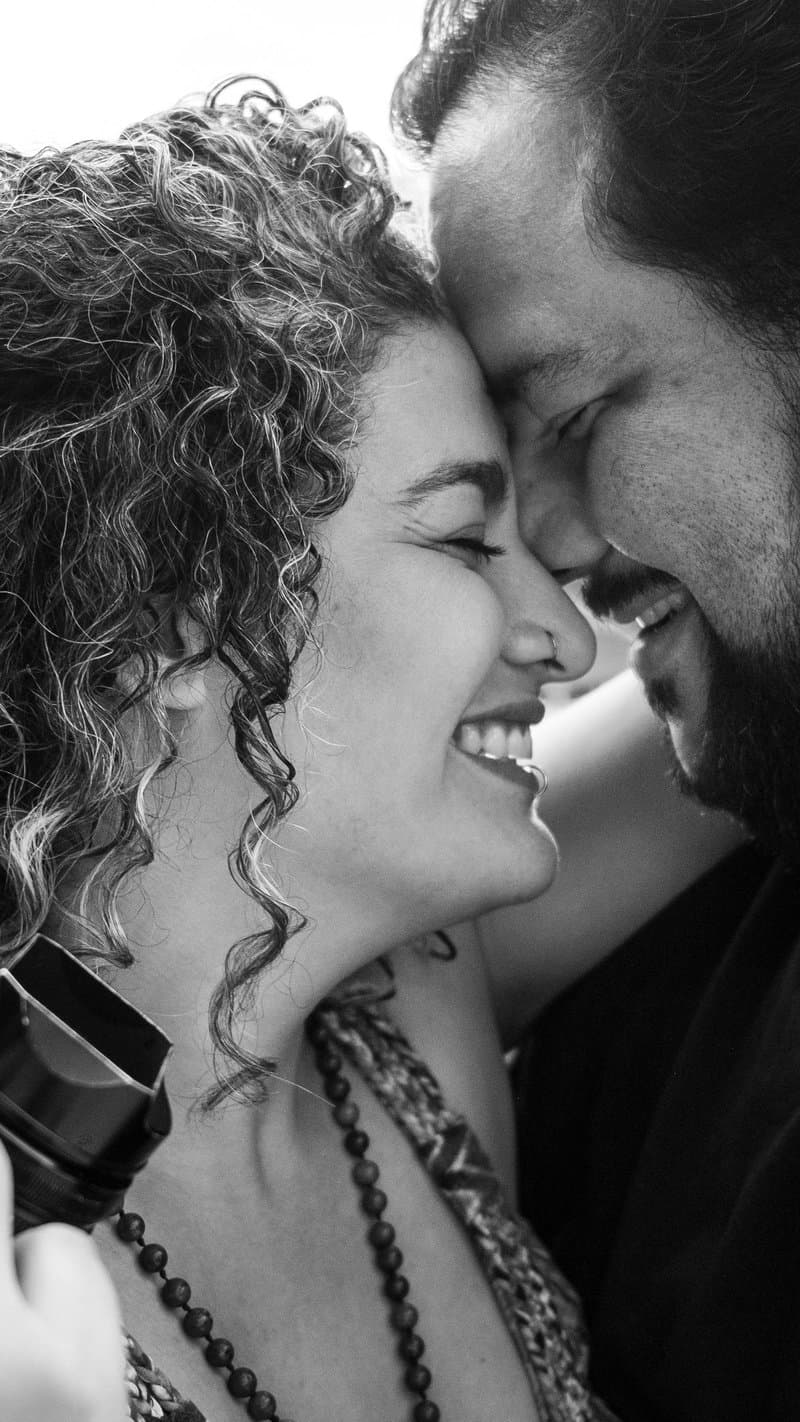 Miguel and Mele of Enamorado Photographers, forehead to forehead, Mele holding a camera