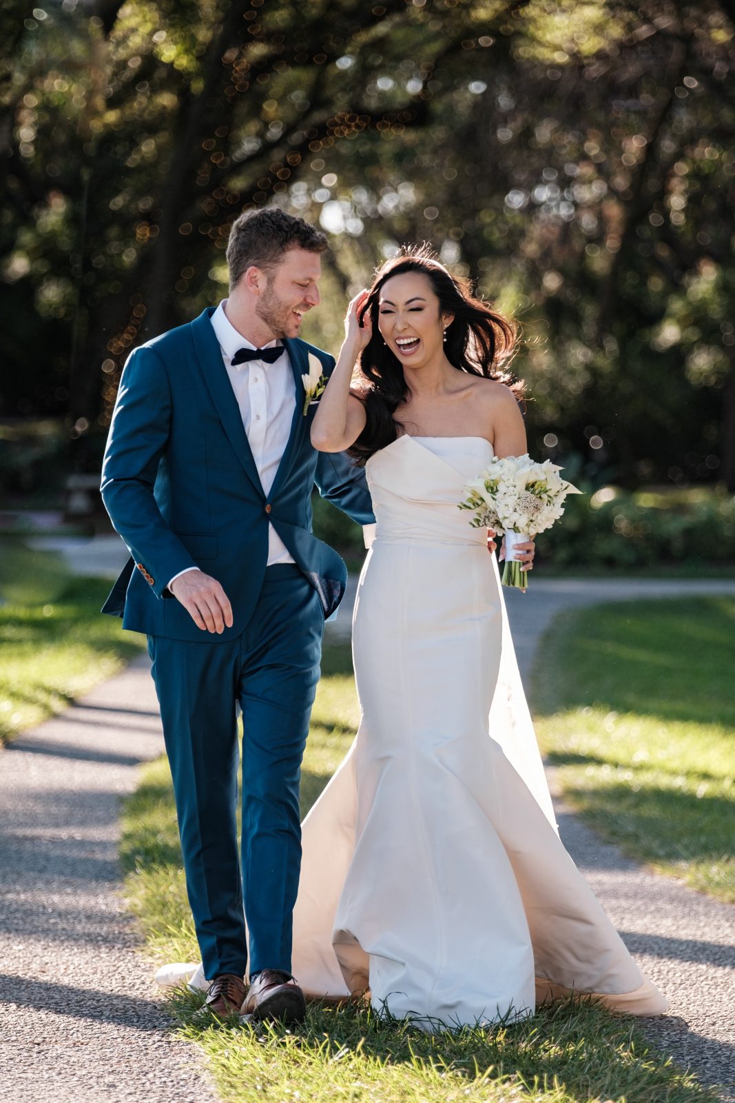 A couple walking and laughing together outdoors after their Miami wedding